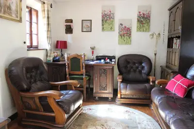 a living room with leather chairs and a couch at Na Gmajni pr' Angležu in Gabrovka