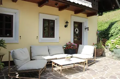 a patio with two couches and a coffee table at Na Gmajni pr' Angležu in Gabrovka