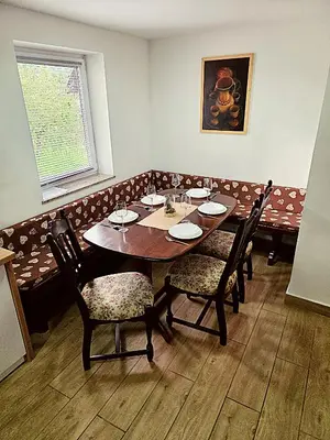 a dining room with a wooden table and chairs at Apartma Pr'Komarjo in Zgornje Gorje