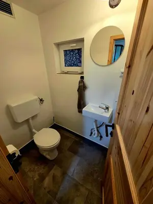 a bathroom with a toilet and a sink and a mirror at Apartma Pr'Komarjo in Zgornje Gorje