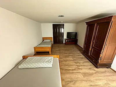 a room with two beds and a tv in it at Apartma Pr'Komarjo in Zgornje Gorje