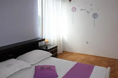 a bedroom with a bed with a purple towel on it at Drift Rock House in Sežana