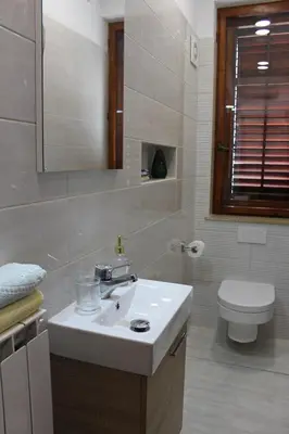 a bathroom with a white sink and a toilet at Drift Rock House in Sežana