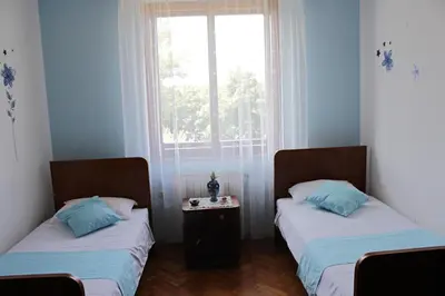 two twin beds in a room with a window at Drift Rock House in Sežana