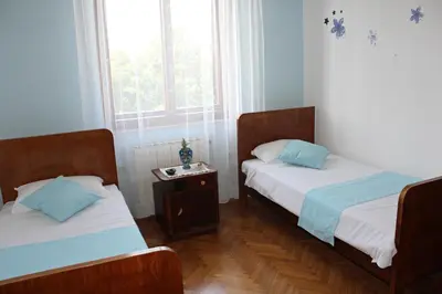 two twin beds in a room with a window at Drift Rock House in Sežana