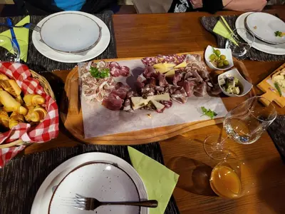 a wooden table with a plate of food on it at Apartments Štrancar wines in Ajdovščina
