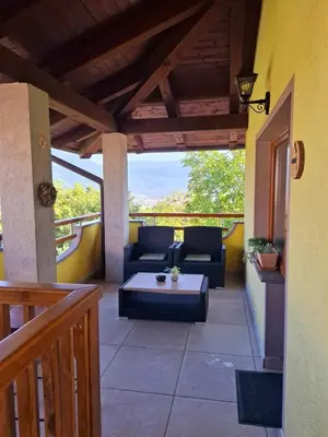 a patio with a couch and a table on a balcony at Apartments Štrancar wines in Ajdovščina