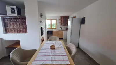 a kitchen with a wooden table and a refrigerator at Hiša nad vinogradom in Ptuj