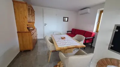 a dining room with a table and a red couch at Hiša nad vinogradom in Ptuj