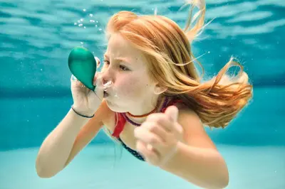 a young girl in a swimming pool looking in a mirror at Hotel Čatež - Terme Čatež in Čatež ob Savi