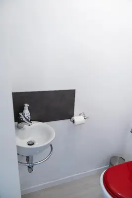 a bathroom with a white sink and a red toilet at Studio M&M in Nova Gorica