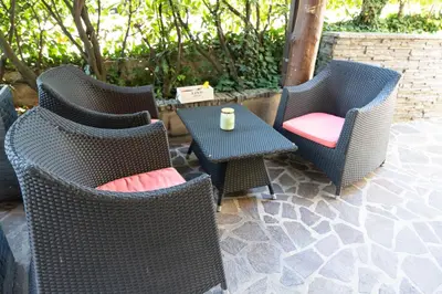 a group of wicker chairs and a table with a cup at Studio M&M in Nova Gorica