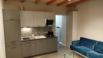 a kitchen with a blue couch in a room at DEKO-LIME apartments in Ljubljana