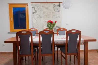 a dining room table with chairs and a vase of flowers at Holiday Home Zelenka in Cerklje na Gorenjskem