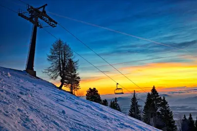 a snow covered slope with a ski lift at sunset at Holiday Home Zelenka in Cerklje na Gorenjskem