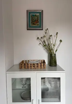a white cabinet with a vase of flowers on it at B&B Apartment for2 in Kranj