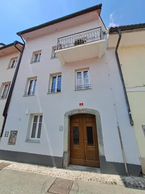 a white building with a wooden door and a balcony at B&B Apartment for2 in Kranj