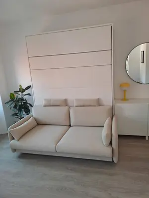 a white couch in a living room with a mirror at B&B Apartment for2 in Kranj