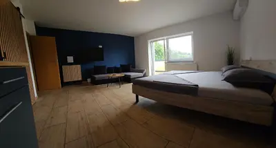 a bedroom with a bed and a large window at Grmač Apartments in Naklo