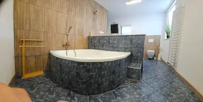 a bathroom with a large bath tub in a room at Grmač Apartments in Naklo