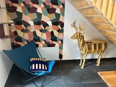 a room with a chair and a deer on the wall at Hiša Blašč Wellness in Kobarid