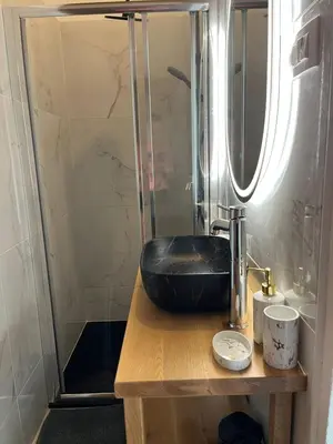 a bathroom with a black sink and a shower at Hiša Blašč Wellness in Kobarid