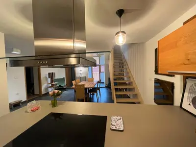 a kitchen and living room with a staircase in a house at Hiša Blašč Wellness in Kobarid
