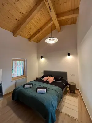 a bedroom with a large bed with a green blanket at Hiša Blašč Wellness in Kobarid