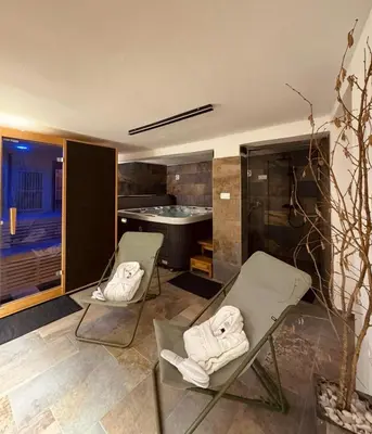 a bathroom with two chairs and a bath tub at Hiša Blašč Wellness in Kobarid