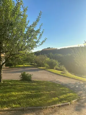 an empty parking lot with a tree and grass at green breeze - private jacuzzi retreat in Žalec