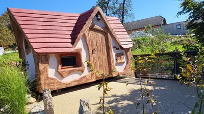 a small dog house with a red roof at Glamping Na Vrhu in Višnja Gora