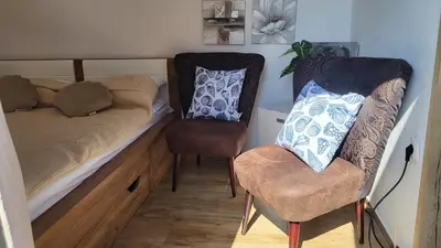 a small bedroom with a bed and a chair at Glamping Na Vrhu in Višnja Gora