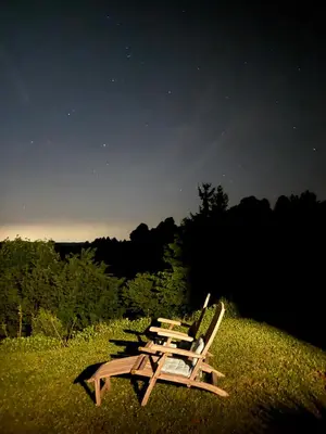 a couple of chairs sitting in the grass at Glamping Na Vrhu in Višnja Gora