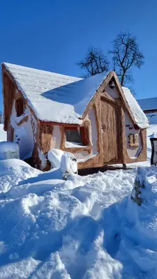 a cabin covered in snow with a roof at Glamping Na Vrhu in Višnja Gora