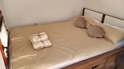 a bed with a pair of slippers on it at Glamping Na Vrhu in Višnja Gora