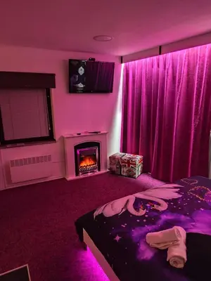 a purple bedroom with a bed and a fireplace at Apartmaji Paradiso in Komen