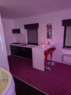 a kitchen with a counter and a stool in a room at Apartmaji Paradiso in Komen