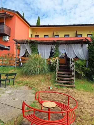 a red bench and a table in front of a building at Apartmaji Paradiso in Komen