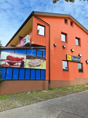 a orange building with a sign on the side of it at Apartmaji Paradiso in Komen