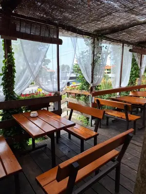 a group of wooden tables and benches on a patio at Apartmaji Paradiso in Komen