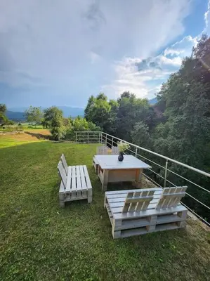 a picnic table and two benches in a field at ZenHouseApartment in Ljubno