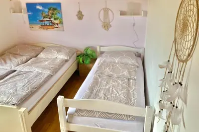 a bedroom with two beds and a chair at ZenHouseApartment in Ljubno