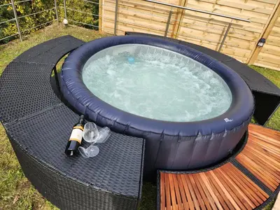 a large hot tub with a table and wine glasses at ZenHouseApartment in Ljubno