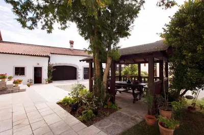 an outdoor patio with a table and a tree at Apartmaji Žnidarčič in Divača