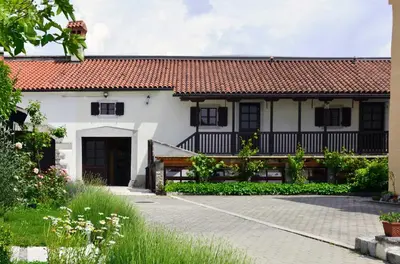 a white house with a red roof and a driveway at Apartmaji Žnidarčič in Divača