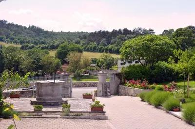 a garden with a fountain and some flowers and trees at Apartmaji Žnidarčič in Divača