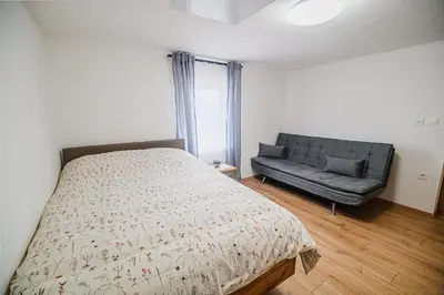 a bedroom with a bed and a couch at Apartment Trta with Vineyard View in Bistrica ob Sotli