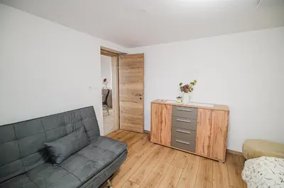 a living room with a couch and a dresser at Apartment Trta with Vineyard View in Bistrica ob Sotli