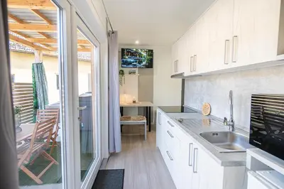 a kitchen with white cabinets and a sink at Hiškovec - Holiday Village in Trebnje
