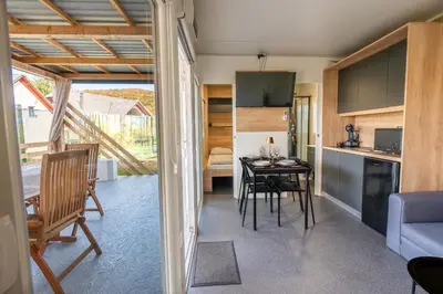 a kitchen and living room with a table and chairs at Hiškovec - Holiday Village in Trebnje